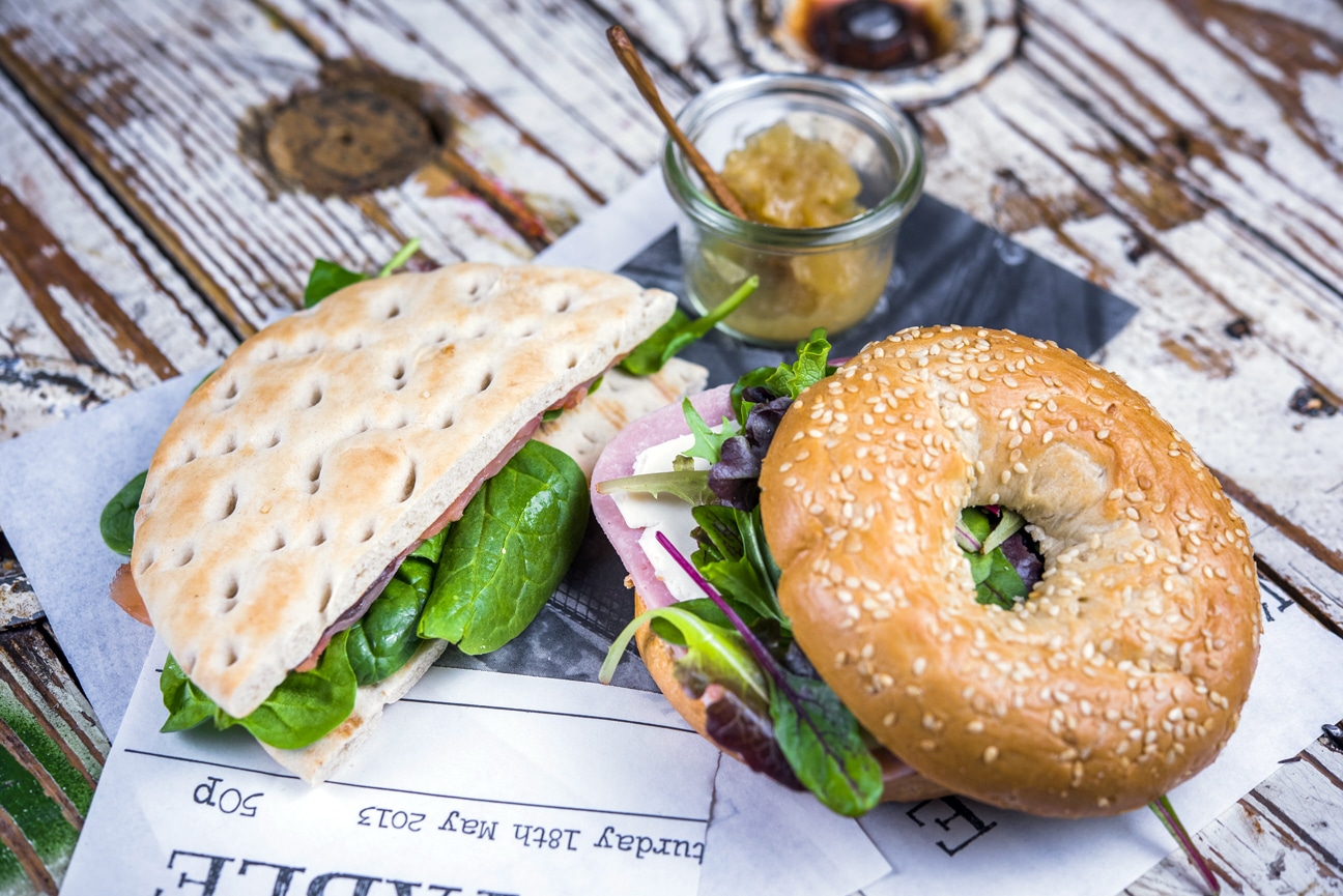 Desayunos salados 7 Bagel de semillas de amapola con jam%C3%B3n york queso lechuga y cebolla caramelizada Bendita Locura