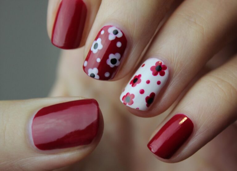 Manicura con diseño floral en tonos rojos y blancos