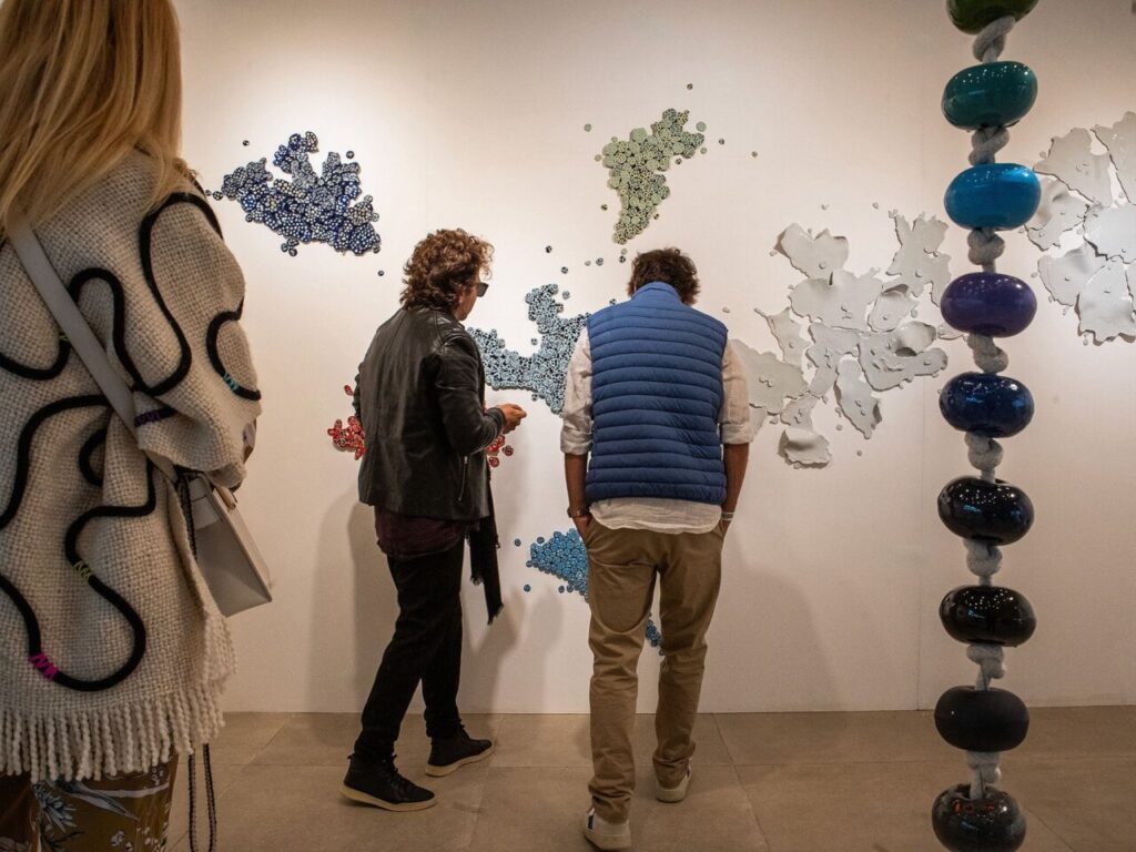 Personas observando obras de arte en una galería contemporánea