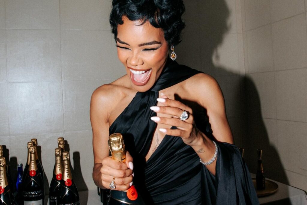 Mujer sonriente sosteniendo una botella de champán en los Globos de Oro 2026