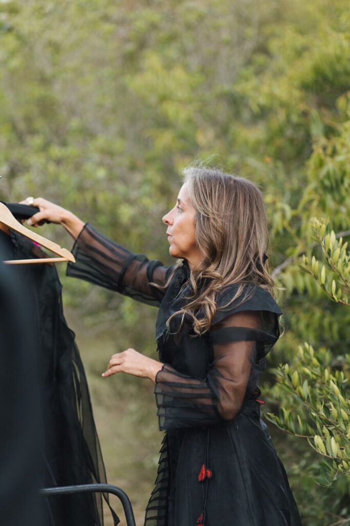 Ana Livni ajustando una prenda en un entorno natural