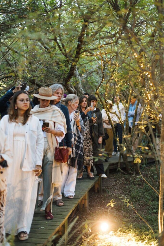 Grupo de personas caminando por un sendero en un bosque con luces