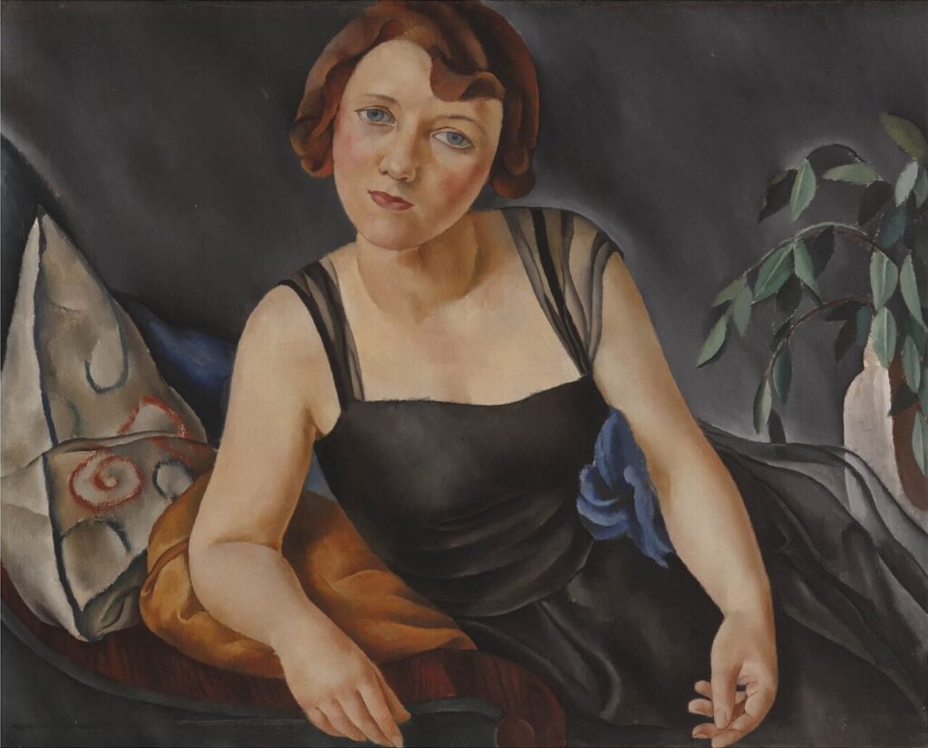 Retrato de una mujer en un sillón con fondo oscuro y plantas