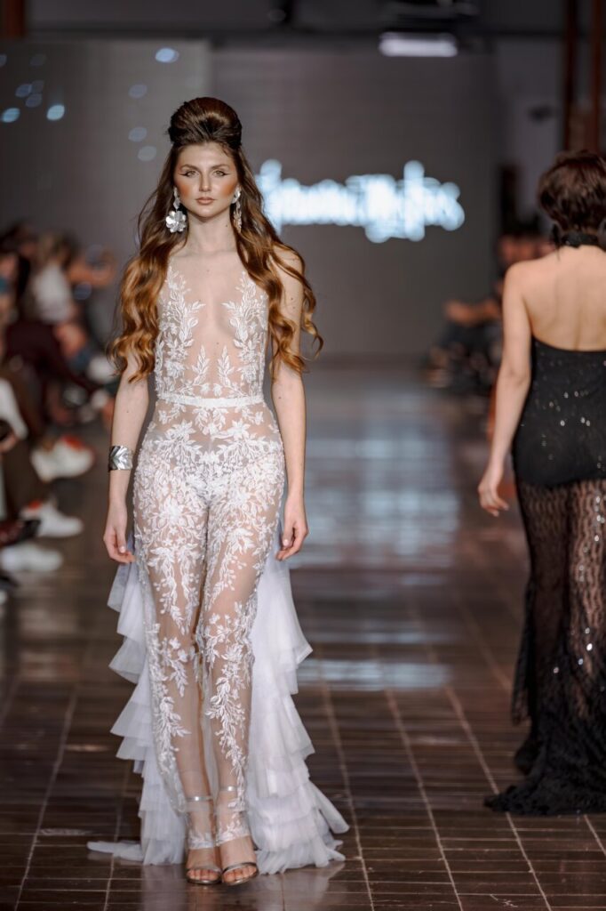 Modelo en pasarela con vestido de novia transparente y detalles florales