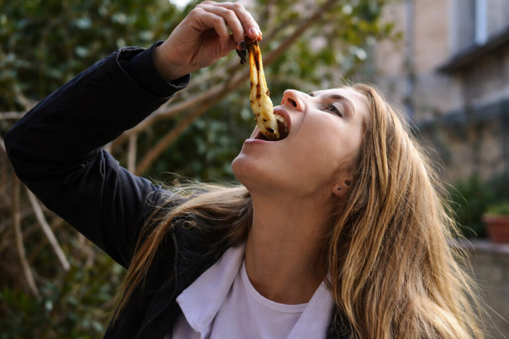 Persona disfrutando de un calçot asado en Mallorca
