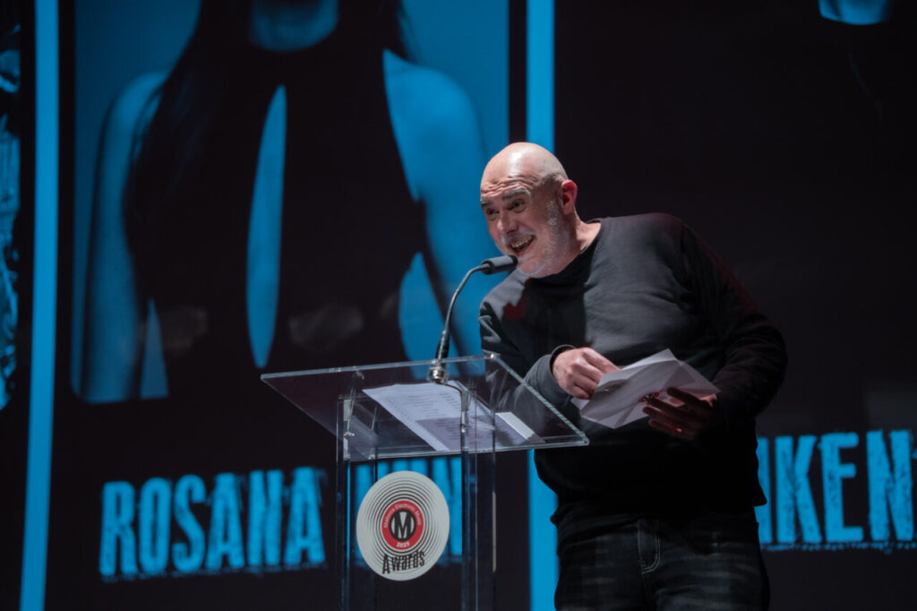 Presentador en la Gala MEM Awards con micrófono y papeles en mano