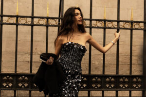 Modelo en vestido de alta costura frente a una reja dorada en París