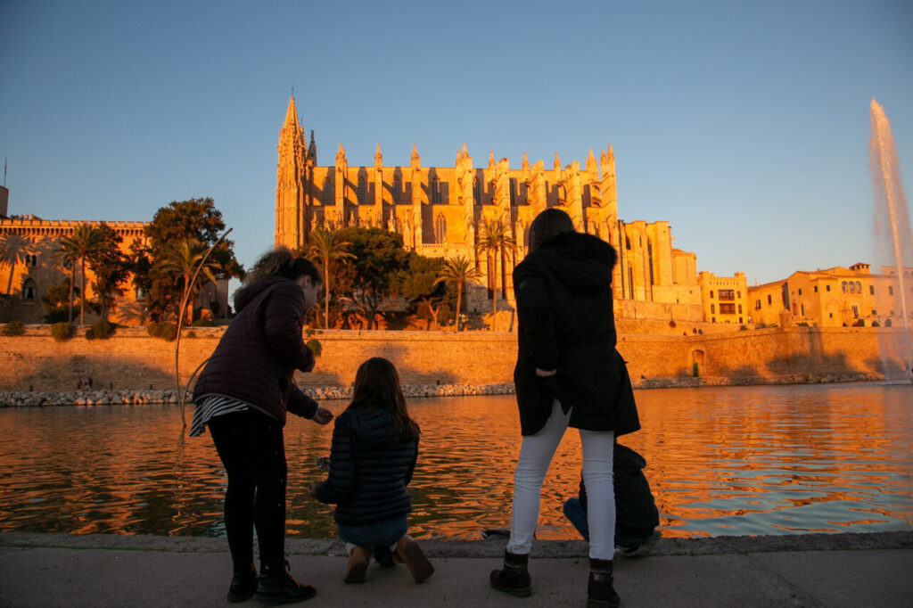 Vista de la Catedral de Palma al atardecer con personas en primer plano