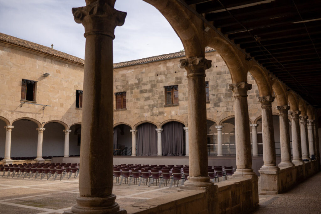 Vista del Claustre de Sant Domingo en Pollença, Mallorca, con columnas y asientos.