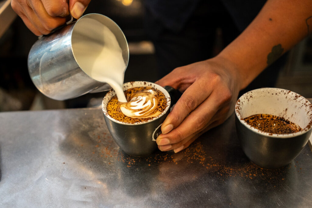 Dos o tres cafés al día, menos demencia: qué se sabe (y qué no) 3 Barista vertiendo leche en una taza de café con arte latte