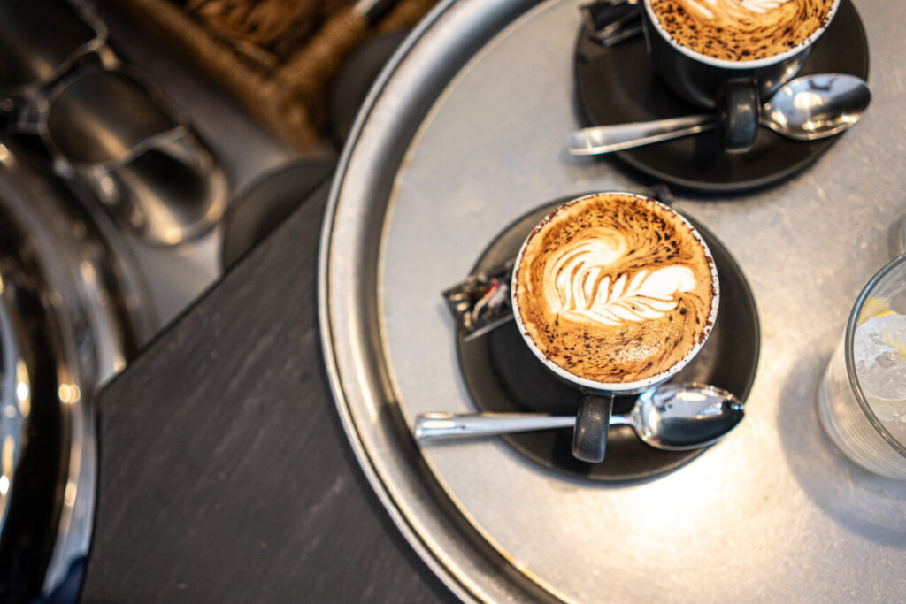 Tazas de café con espuma decorativa sobre una bandeja