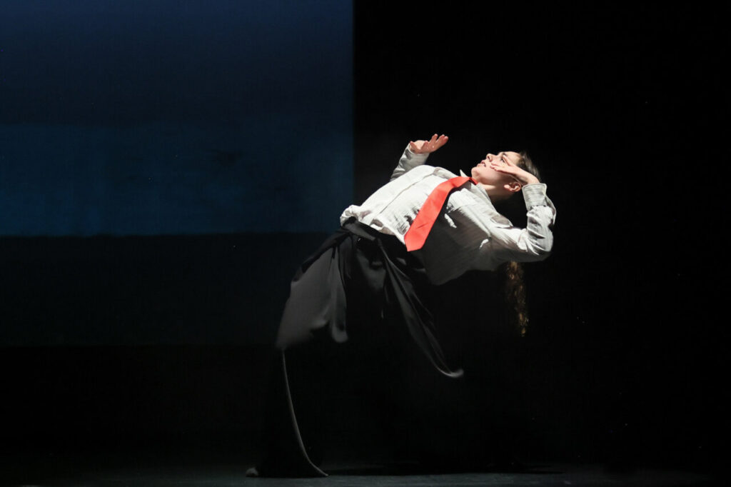 Bailarina en escena interactuando con una obra de arte en un museo.