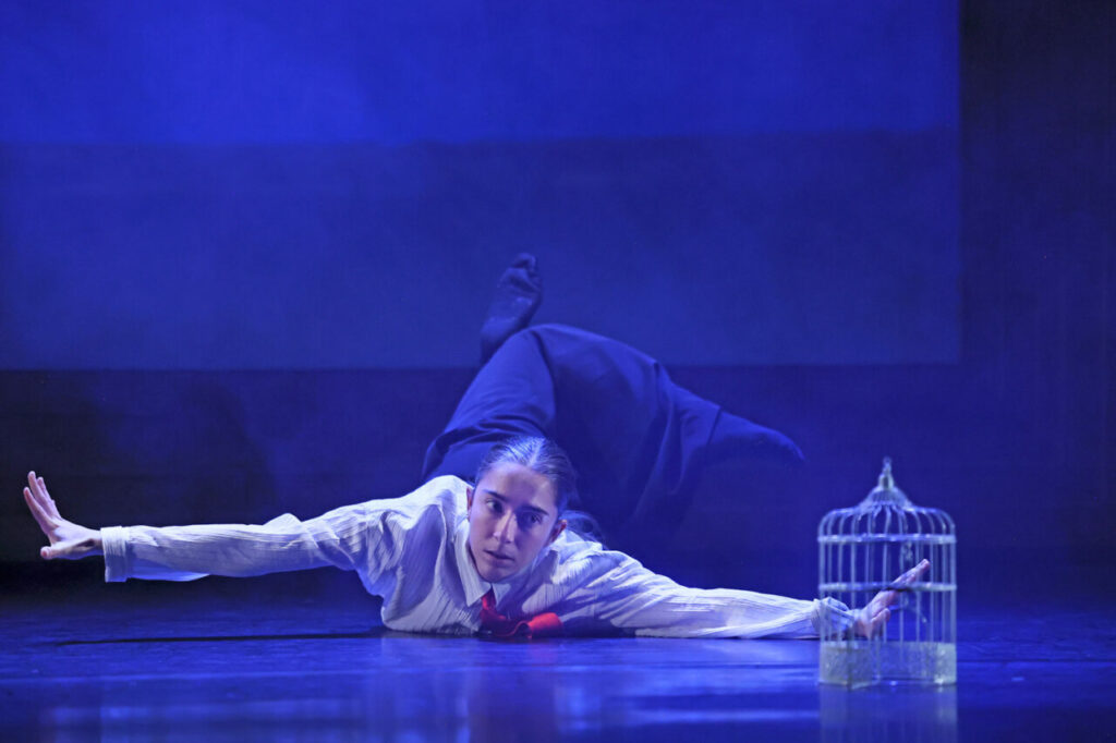 Bailarina en escena interactuando con una obra de arte en un museo.