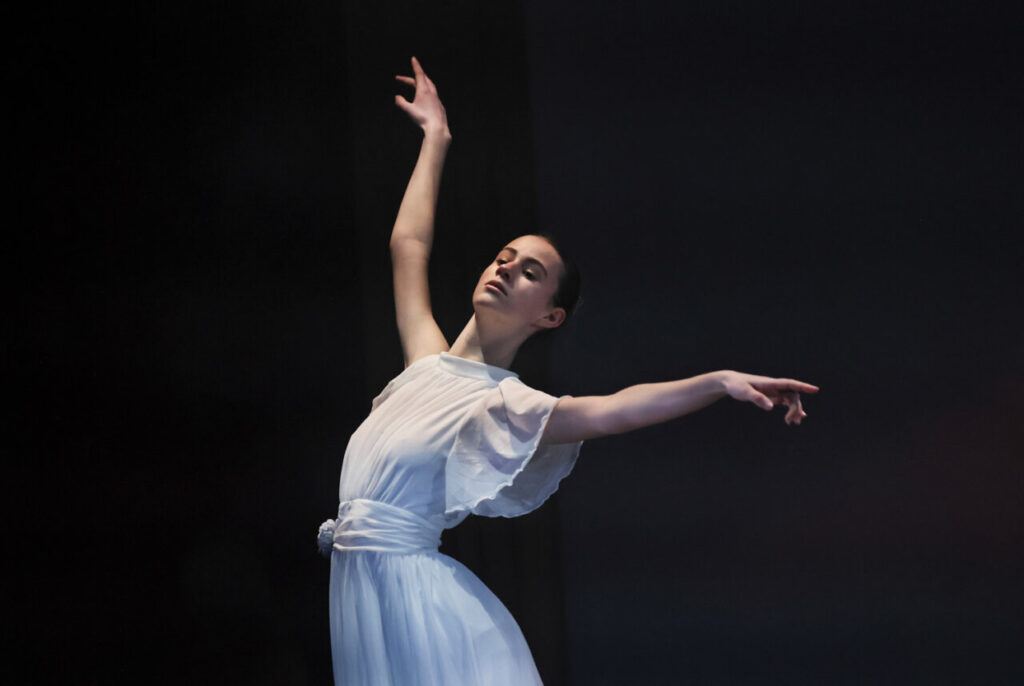 Bailarina en escena interactuando con obras de arte en un museo.