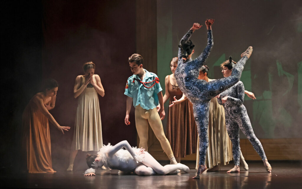 Bailarines interactuando en un escenario con elementos artísticos.