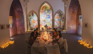 Evento artístico en la iglesia de Torralba con obras de Piro y velas encendidas.