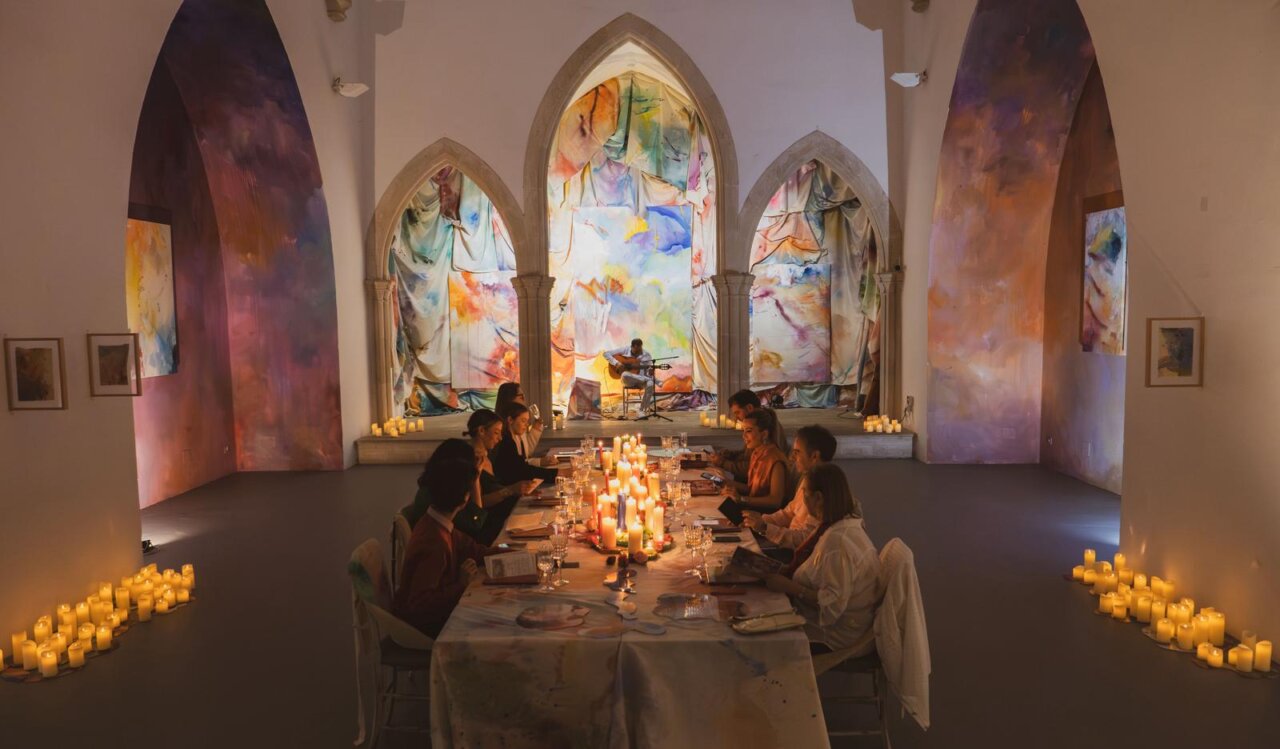 Evento artístico en la iglesia de Torralba con obras de Piro y velas encendidas.