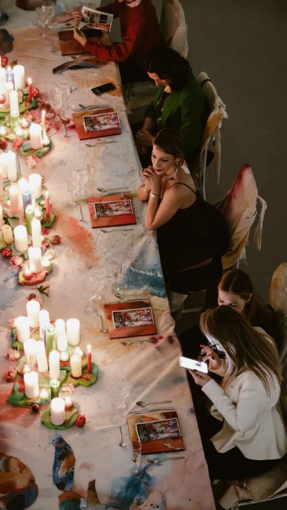 La magia de la creación: cómo Piro transforma la oscuridad en color en sus obras 4 Mesa decorada con velas y obras de arte en un evento de Piro.