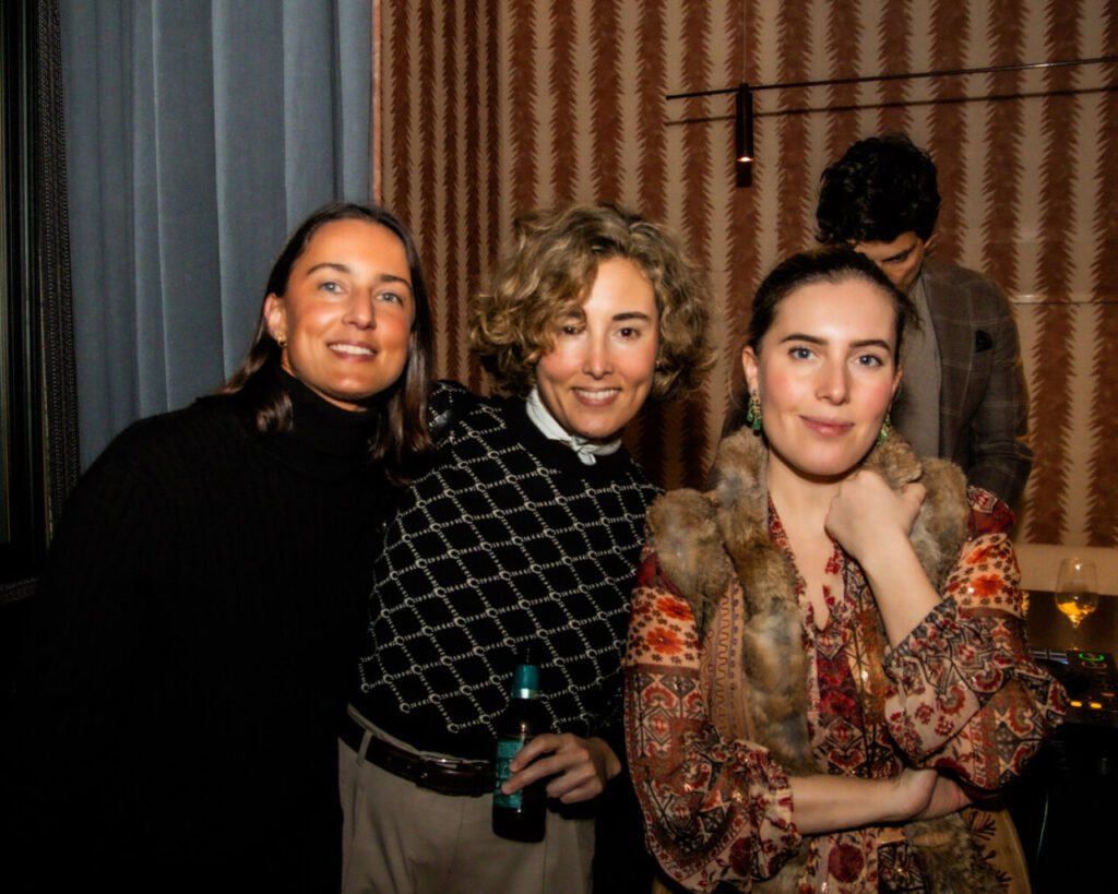 Cupa Stone X Pablo Erroz: Cuando la piedra se convierte en luz 5 Tres mujeres posando juntas en un evento social con decoraciones elegantes.