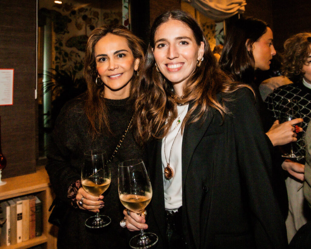 Cupa Stone X Pablo Erroz: Cuando la piedra se convierte en luz 9 Dos mujeres sonrientes sosteniendo copas de vino en un evento social