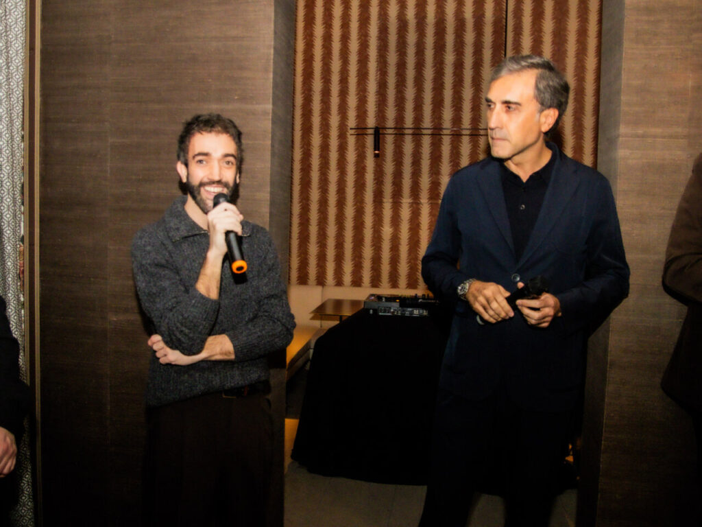 Cupa Stone X Pablo Erroz: Cuando la piedra se convierte en luz 12 Dos hombres en un evento, uno habla con un micrófono.