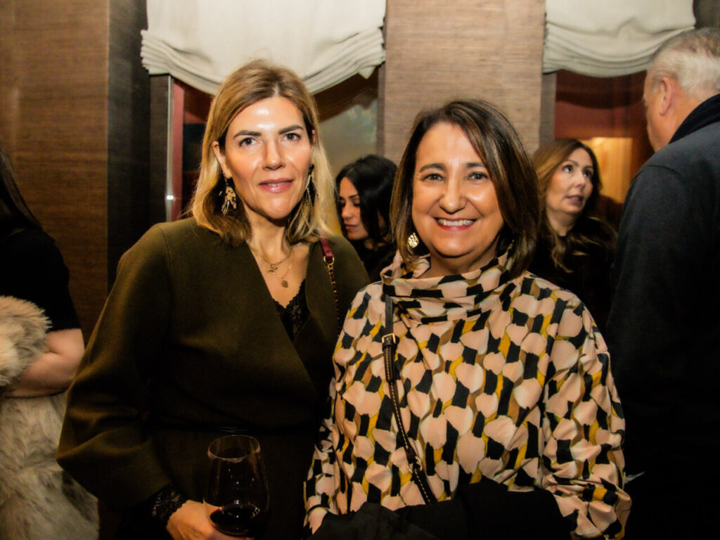 Cupa Stone X Pablo Erroz: Cuando la piedra se convierte en luz 42 Dos mujeres sonriendo en un evento social con copas de vino.