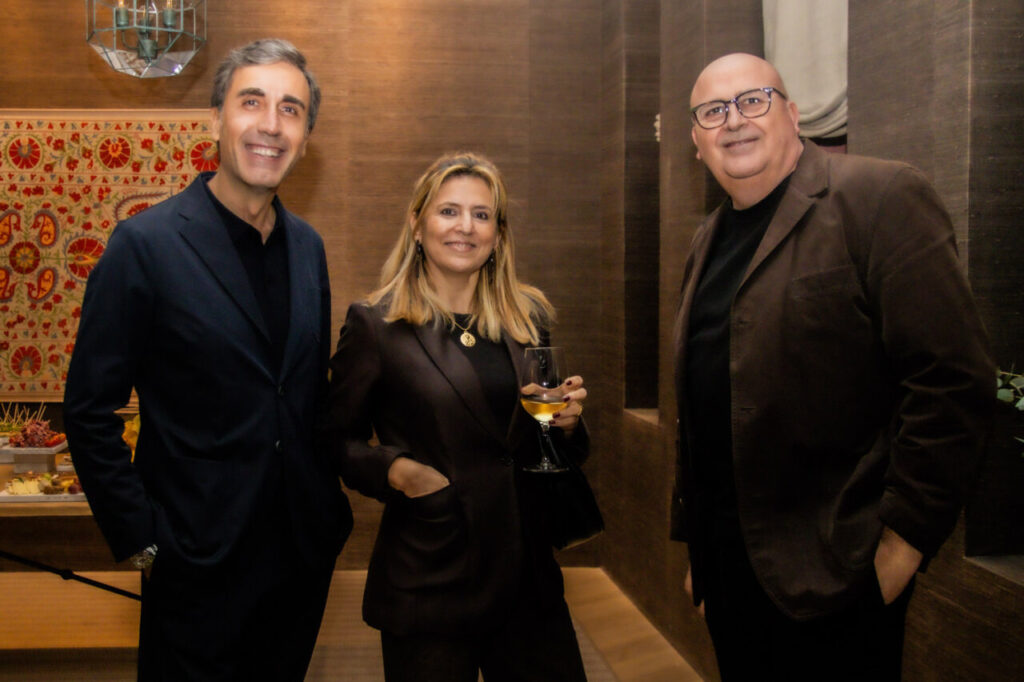 Cupa Stone X Pablo Erroz: Cuando la piedra se convierte en luz 24 Tres personas sonriendo en un evento social elegante.