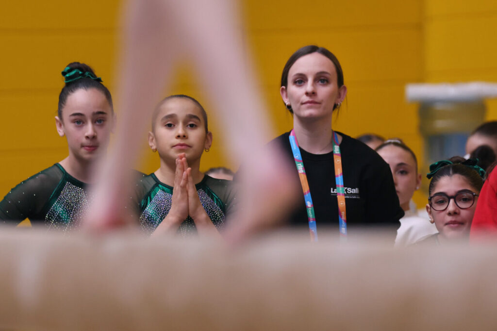 La Liga Iberdrola GAF 2026 arranca en Palma: 230 gimnastas, 26 equipos y tres clubes mallorquines en casa 13 Gimnastas y entrenadora observando una competencia de gimnasia