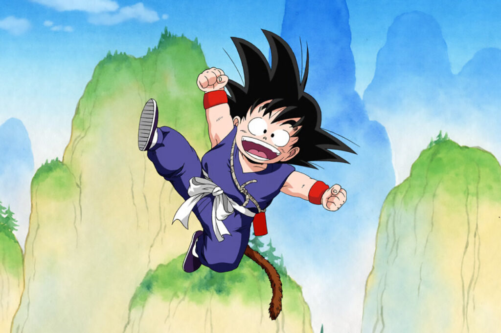 Goku de Dragon Ball saltando con alegría en un paisaje montañoso