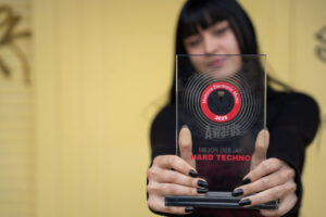 Mujer sosteniendo un premio de música electrónica en 2025
