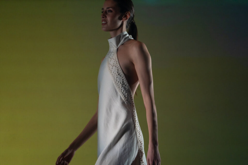 Modelo luciendo un vestido de moda artesana en pasarela