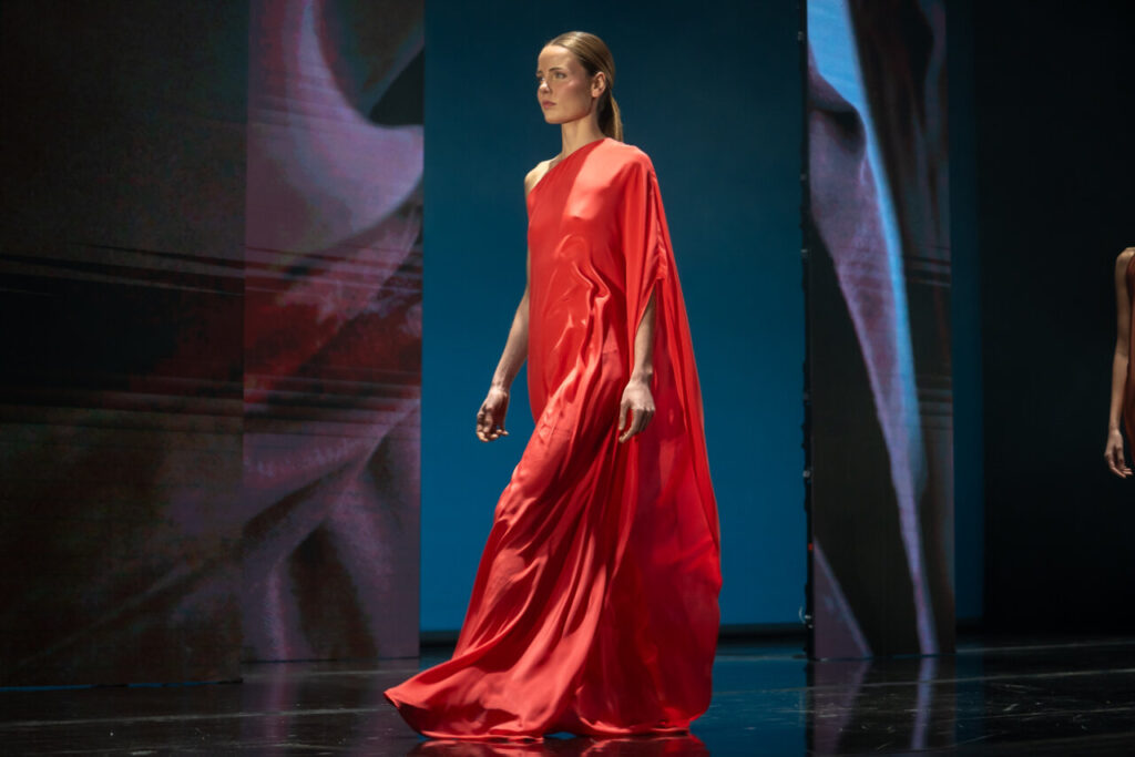 Modelo en pasarela con vestido rojo en desfile de moda artesana en Mallorca