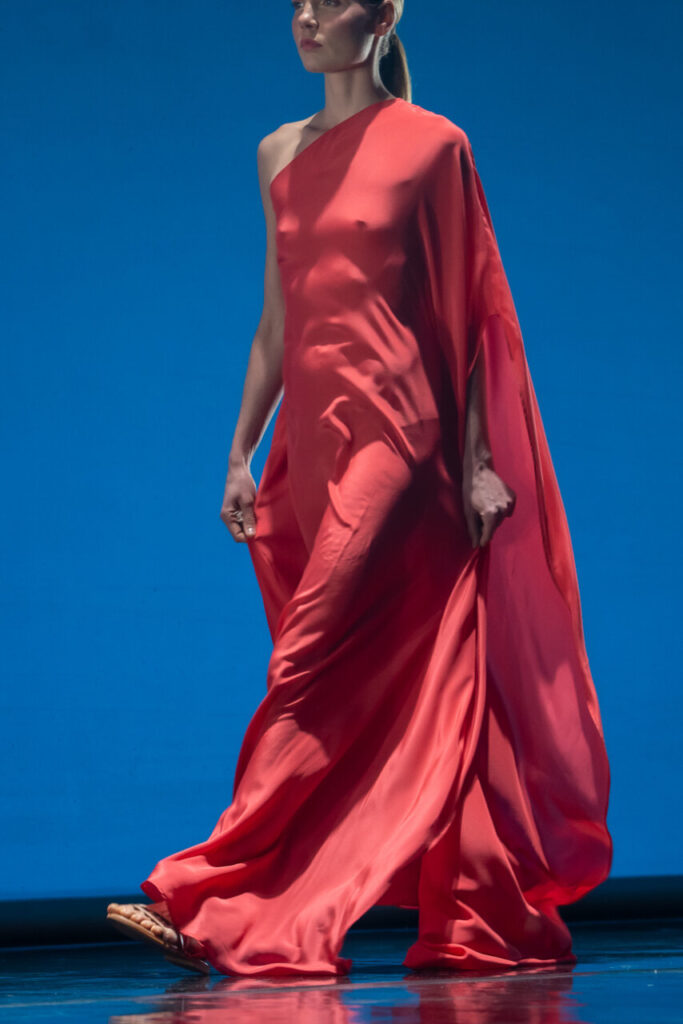 Modelo luciendo un vestido rojo en pasarela de moda en Mallorca
