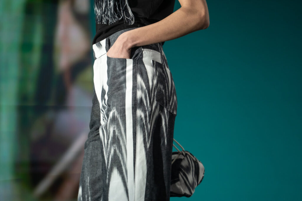 Modelo exhibiendo un diseño de moda artesana en pasarela