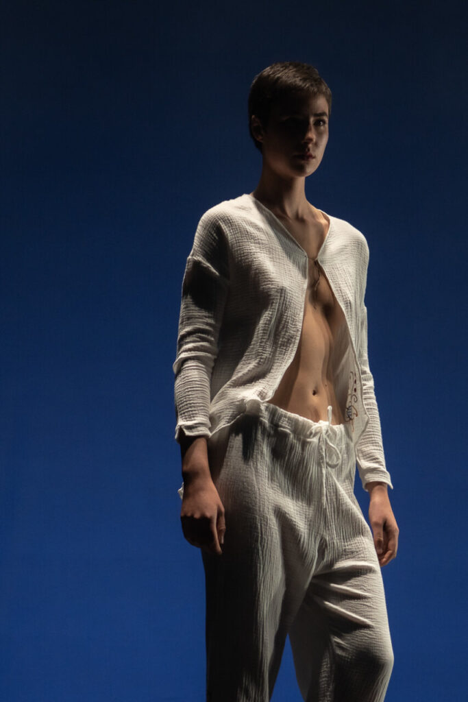 Modelo en pasarela con atuendo blanco en desfile de moda artesana