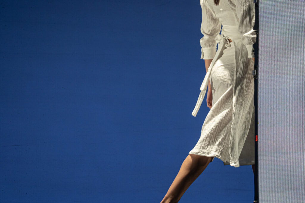 Modelo luciendo vestido blanco en desfile de moda en Mallorca