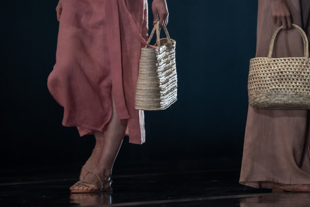 Modelos con ropa artesanal y bolsos de palma en pasarela