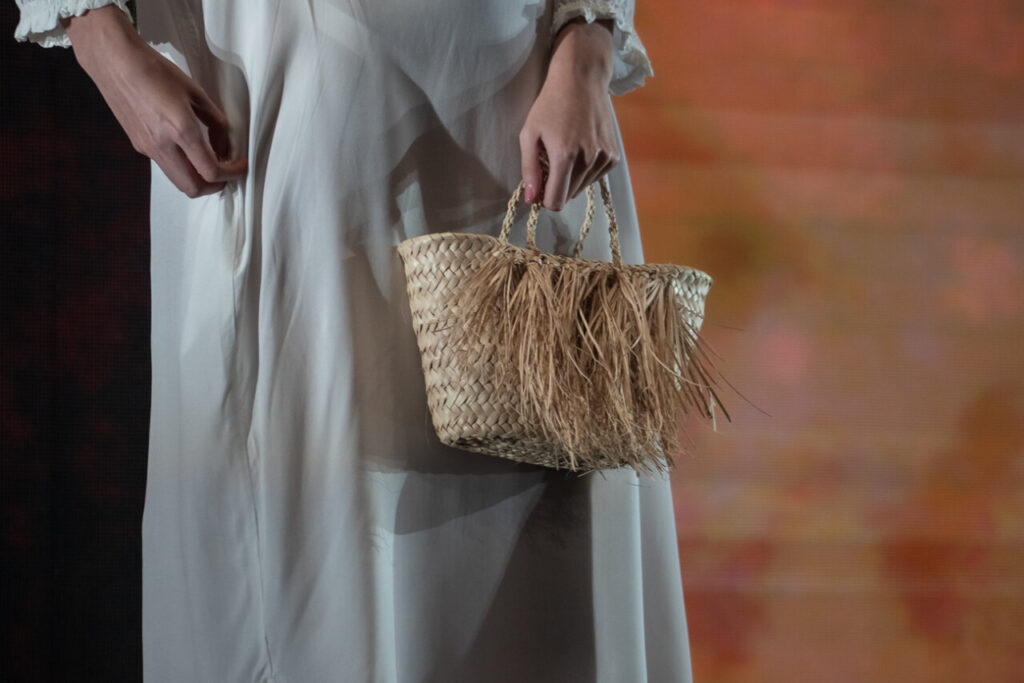Modelo sostiene un bolso de palma durante el desfile de moda en Mallorca
