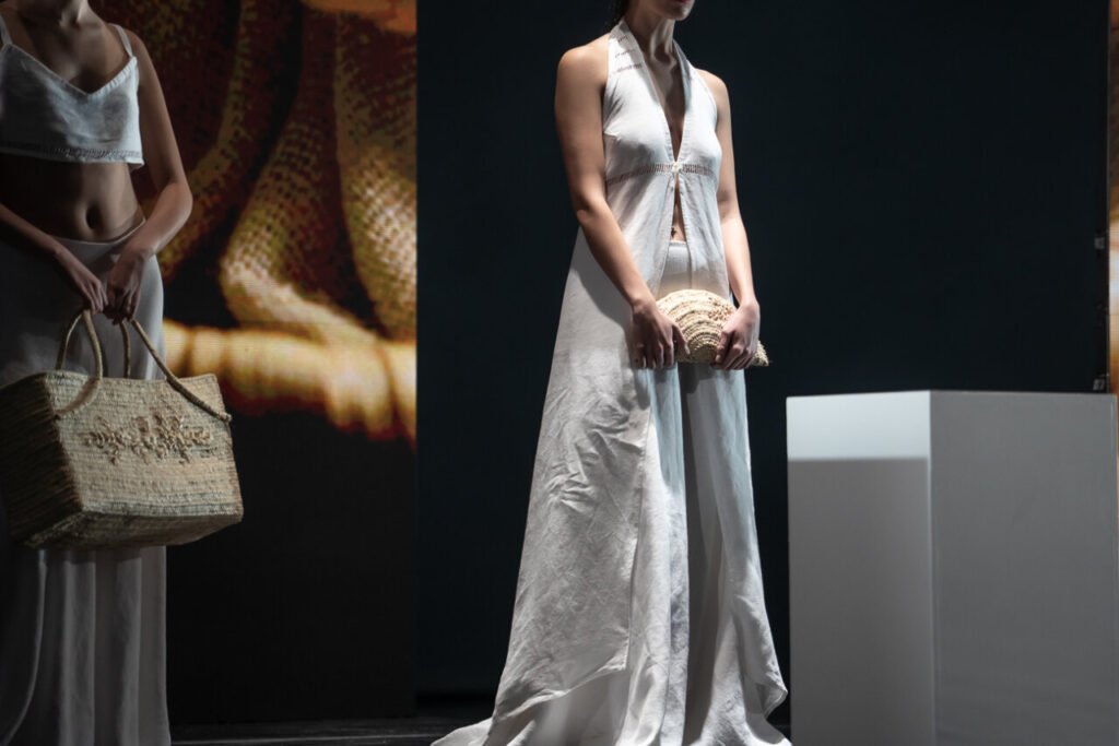 Modelo en pasarela con ropa artesanal de Mallorca y bolso de mano