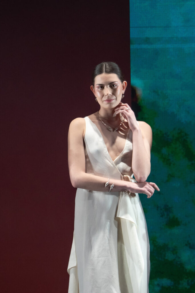 Modelo luciendo un vestido blanco en el desfile de moda artesana de Mallorca
