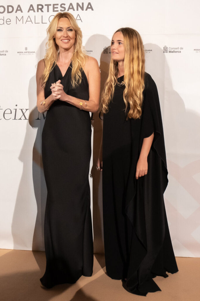 Dos mujeres en el desfile de Moda Artesana de Mallorca luciendo elegantes vestidos negros.