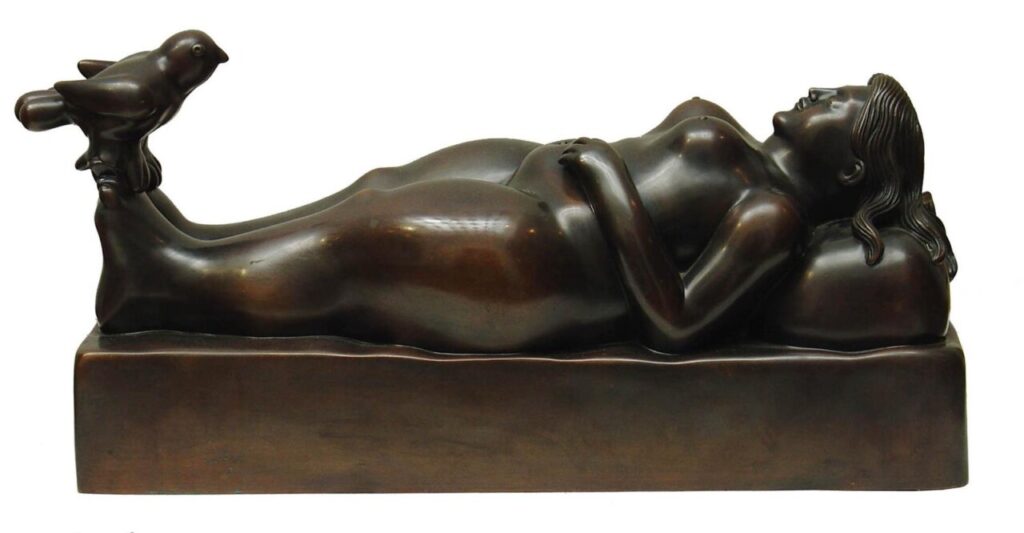 Escultura de una mujer recostada con un pájaro sobre su pie