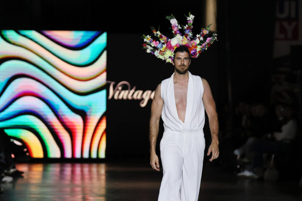 Modelo masculino en pasarela con flores en la cabeza en evento nupcial