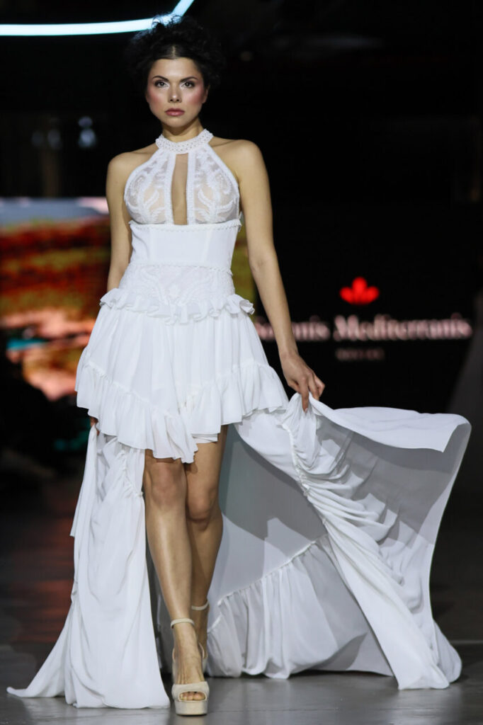 Modelo en pasarela con vestido de novia blanco en Motorworld Mallorca.