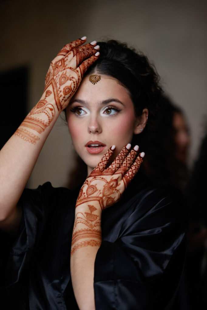 Modelo con henna en manos y frente en evento nupcial