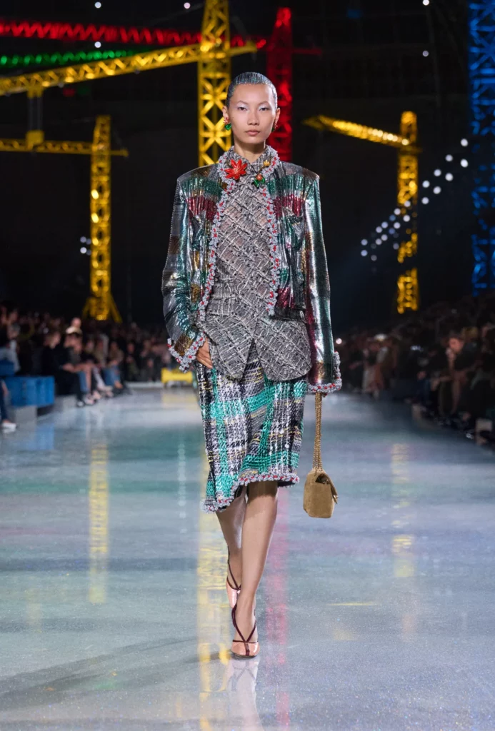 Modelo en pasarela con traje de tweed en desfile de Chanel