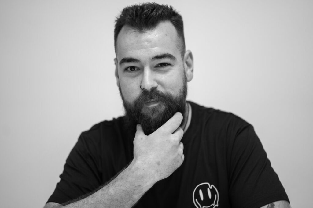Retrato en blanco y negro de un hombre con barba y camiseta negra
