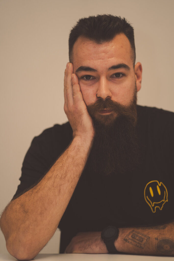 Retrato de un hombre con barba y camiseta negra pensativo