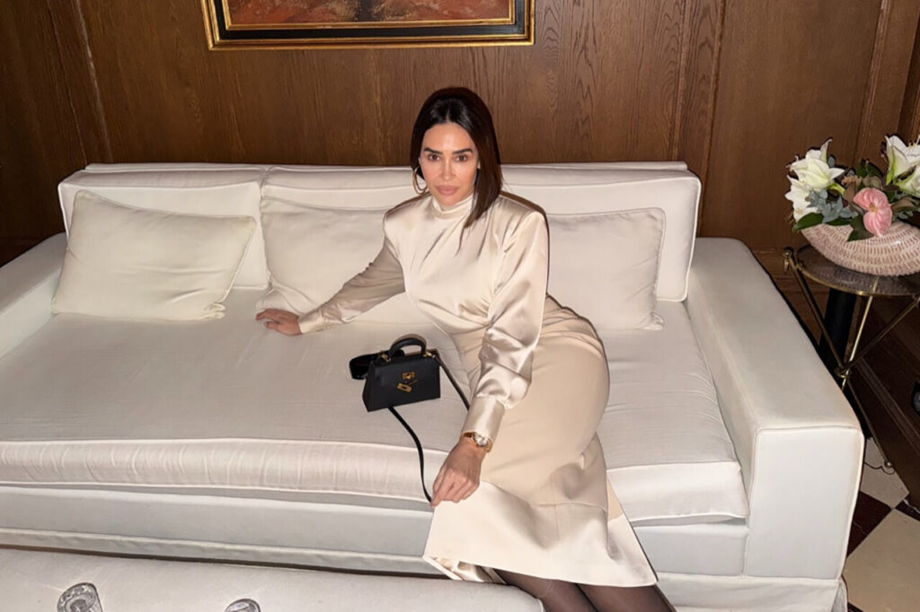 Vicky Martín Berrocal sentada en un sofá elegante con un bolso negro