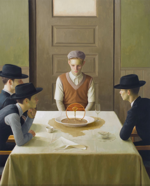 Cuatro personas sentadas alrededor de una mesa con una obra de arte en el centro.